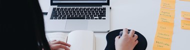 woman using a laptop with post it notes