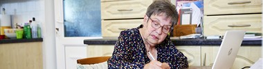 Woman using a computer and taking notes