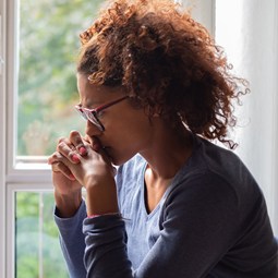 sad woman beside window